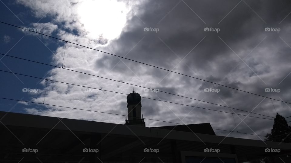 Sonne durch Wolkendecke mit Kirche im Hintergrund