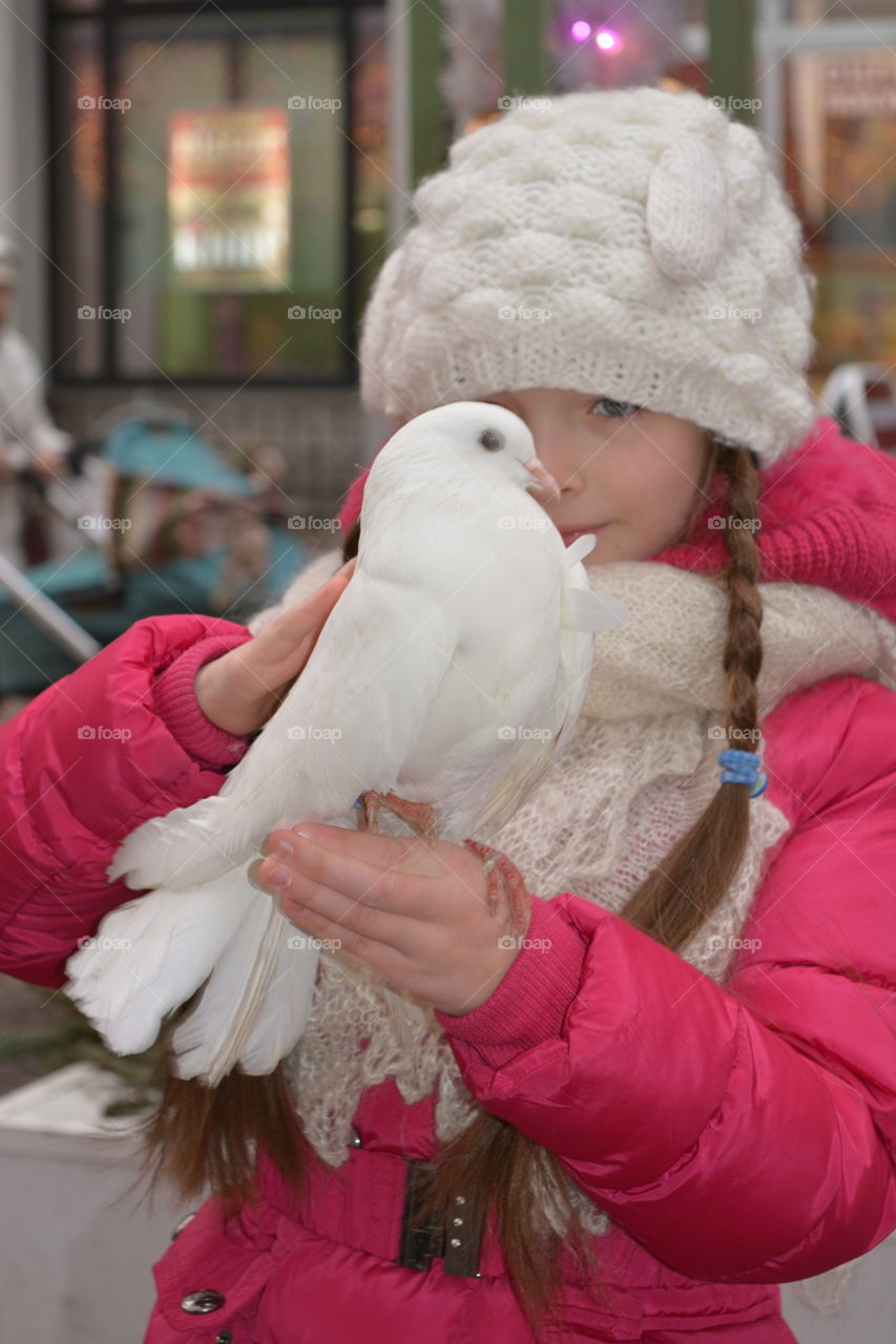 Girl carrying pigeon in hand
